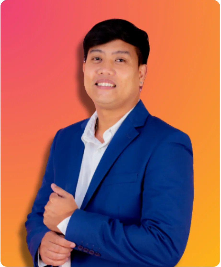 A man wearing a blue blazer and white shirt smiles confidently with his arms crossed.